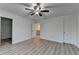 A large bedroom with wood-look flooring, ceiling fan and access to closet and hallway at 4155 Winterberry Rd, Cumming, GA 30040