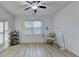 Neat bedroom space with a ceiling fan and a desk underneath the window with blinds at 4155 Winterberry Rd, Cumming, GA 30040