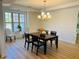 Bright dining room with modern chandelier, wood floors, and wainscoting at 4155 Winterberry Rd, Cumming, GA 30040