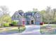 Charming brick home with a well-manicured lawn and a curved driveway at 4155 Winterberry Rd, Cumming, GA 30040