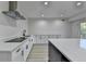 Well-lit kitchen showcasing white cabinets, stainless steel hood, and quartz countertops at 4155 Winterberry Rd, Cumming, GA 30040