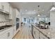 Spacious kitchen with white cabinetry, granite countertops, and stainless steel appliances overlooking living spaces at 4155 Winterberry Rd, Cumming, GA 30040