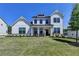 Inviting two-story home featuring a white board and batten exterior, lush lawn and covered porch at 105 Aspen Hall Dr, Canton, GA 30115