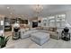 Open-concept living room with a modern chandelier, large sectional sofa, and views into the kitchen at 105 Aspen Hall Dr, Canton, GA 30115