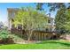 Lush green backyard featuring a deck with seating, a lower patio and expansive green lawn with mature trees at 18 Rose Gate Ne Dr, Atlanta, GA 30342