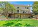 Expansive backyard with lush green lawn, mature trees, a deck with outdoor seating, and fenced-in space at 18 Rose Gate Ne Dr, Atlanta, GA 30342