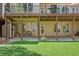 Backyard featuring a spacious covered patio, artificial turf, and a cozy seating area with a stone path at 18 Rose Gate Ne Dr, Atlanta, GA 30342