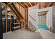 Unfinished basement with exposed beams, wooden staircase, and an entrance to a finished section with carpet at 18 Rose Gate Ne Dr, Atlanta, GA 30342