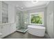Modern bathroom boasts soaking tub, glass enclosed shower and window with a view at 18 Rose Gate Ne Dr, Atlanta, GA 30342