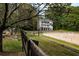 View of equestrian facility with horse jumping arena and large building with multiple balconies at 18 Rose Gate Ne Dr, Atlanta, GA 30342