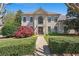 Stately home featuring manicured landscaping, a brick pathway, and a symmetrical facade with large arched window at 18 Rose Gate Ne Dr, Atlanta, GA 30342