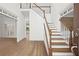 Bright foyer showcasing hardwood floors, white staircase with wood trim, and open floor plan at 18 Rose Gate Ne Dr, Atlanta, GA 30342