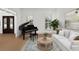 Stylish living room with a grand piano, white sofa, area rug, and windows offering natural light at 18 Rose Gate Ne Dr, Atlanta, GA 30342