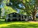 Charming two-story home with a lush green lawn and mature trees providing shade at 213 Mccready Dr, Dallas, GA 30157