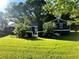 Charming home with manicured lawn, mature trees, with white flowering bushes and dark exterior at 213 Mccready Dr, Dallas, GA 30157