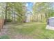 Expansive backyard featuring lush greenery, mature trees, and a charming storage shed at 315 Fieldridge Dr, Lawrenceville, GA 30045