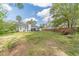 Spacious backyard with manicured lawn, mature trees, and the rear elevation of the home at 315 Fieldridge Dr, Lawrenceville, GA 30045