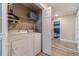 Well-lit laundry area featuring a modern washer, dryer, and plenty of shelving for storage and organization at 315 Fieldridge Dr, Lawrenceville, GA 30045
