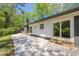 View of the back patio featuring a brick chimney, large sliding doors, and stylish gray brick facade at 3350 Pine Meadow Nw Rd, Atlanta, GA 30327
