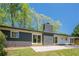 Back exterior showcasing painted brick, a patio, large windows and a manicured lawn at 3350 Pine Meadow Nw Rd, Atlanta, GA 30327