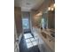 Bathroom featuring a double sink vanity with stone countertops, tile floors and a tub at 2071 Westside Blvd, Atlanta, GA 30318