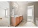 Bright bathroom featuring double sink vanity, and doorways to another bedroom and a walk-in closet at 2602 Avery Park Cir, Atlanta, GA 30360