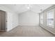 Bright bedroom showcasing neutral walls, ceiling fan, plush carpet, and natural light from multiple windows at 2602 Avery Park Cir, Atlanta, GA 30360