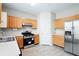 Bright kitchen featuring stainless steel refrigerator, gas range, and wood cabinets at 2602 Avery Park Cir, Atlanta, GA 30360