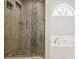 Bathroom featuring a tile shower, soaking tub, and natural light from an arched window at 161 Hunters Chase, Mcdonough, GA 30253