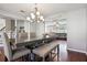 Open-concept dining room with elegant chandelier, gray walls, and hardwood floors, flowing into the living area at 161 Hunters Chase, Mcdonough, GA 30253