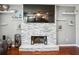 Stylish living room featuring a floor-to-ceiling stone fireplace with a mounted TV, built-in shelving, and hardwood floors at 161 Hunters Chase, Mcdonough, GA 30253