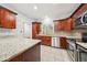 Traditional kitchen features wood cabinets, granite countertops, stainless steel appliances, and a tile floor at 171 Riverview Trl, Roswell, GA 30075