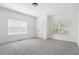 An empty bedroom offers neutral carpet, white walls, a closet, two windows, and overhead lighting at 360 Beracah Sw Trl, Atlanta, GA 30331
