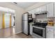 Well-lit kitchen features stainless steel appliances, white cabinetry, and access to the dining room, creating an open and inviting space at 4657 Tartan Ct, Union City, GA 30291