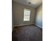 A secondary bedroom with carpet flooring, a window, and neutral painted walls at 8302 N Sterling Lakes Dr, Covington, GA 30014