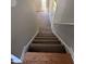 View of carpeted stairs leading towards a door with a glass panel, providing a safe passage at 8302 N Sterling Lakes Dr, Covington, GA 30014