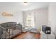 Cozy bedroom with a crib, chair, and window letting in natural light at 1688 Jackson Sq, Atlanta, GA 30318