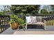 A bench on the deck is adorned with ferns and a decorative pillow at 1770 Bethany Spring, Cumming, GA 30041