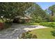 A ranch style home is pictured with a large magnolia tree and a sunny driveway and yard at 1911 Lavista Ne Rd, Atlanta, GA 30329