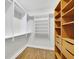Walk-in closet featuring a combination of wooden and white shelving and drawers at 5004 Barnwood Nw Ter, Kennesaw, GA 30152