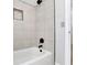 Shower and bath area with white tile and black hardware at 5004 Barnwood Nw Ter, Kennesaw, GA 30152