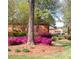 Inviting front yard with vibrant azaleas, mature trees, and lush green grass at 600 Bedfort Dr, Duluth, GA 30096