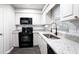 Well-lit kitchen with white cabinets, granite countertops, and black appliances at 600 Bedfort Dr, Duluth, GA 30096
