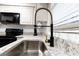 Close up of a stainless steel kitchen sink with a modern spring faucet and granite countertops at 600 Bedfort Dr, Duluth, GA 30096