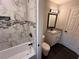 Updated bathroom featuring marble tile shower, modern vanity, and dark wood-look flooring at 7817 Mattie Mccoy Ln, Winston, GA 30187