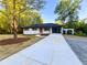 Single story brick home on a sprawling lot with a long concrete driveway and attached carport at 7817 Mattie Mccoy Ln, Winston, GA 30187