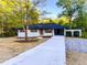 Well-manicured front yard and charming ranch-style home with attached carport and fresh concrete driveway at 7817 Mattie Mccoy Ln, Winston, GA 30187
