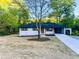 Charming, updated home featuring light brick, dark trim, wooden shutters, and a convenient carport at 7817 Mattie Mccoy Ln, Winston, GA 30187