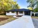 Landscaped front yard with charming brick home with black trim, natural wood shutters, and a covered carport at 7817 Mattie Mccoy Ln, Winston, GA 30187