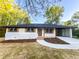 Charming renovated home with white brick, black trim, natural wood shutters, and a covered carport at 7817 Mattie Mccoy Ln, Winston, GA 30187